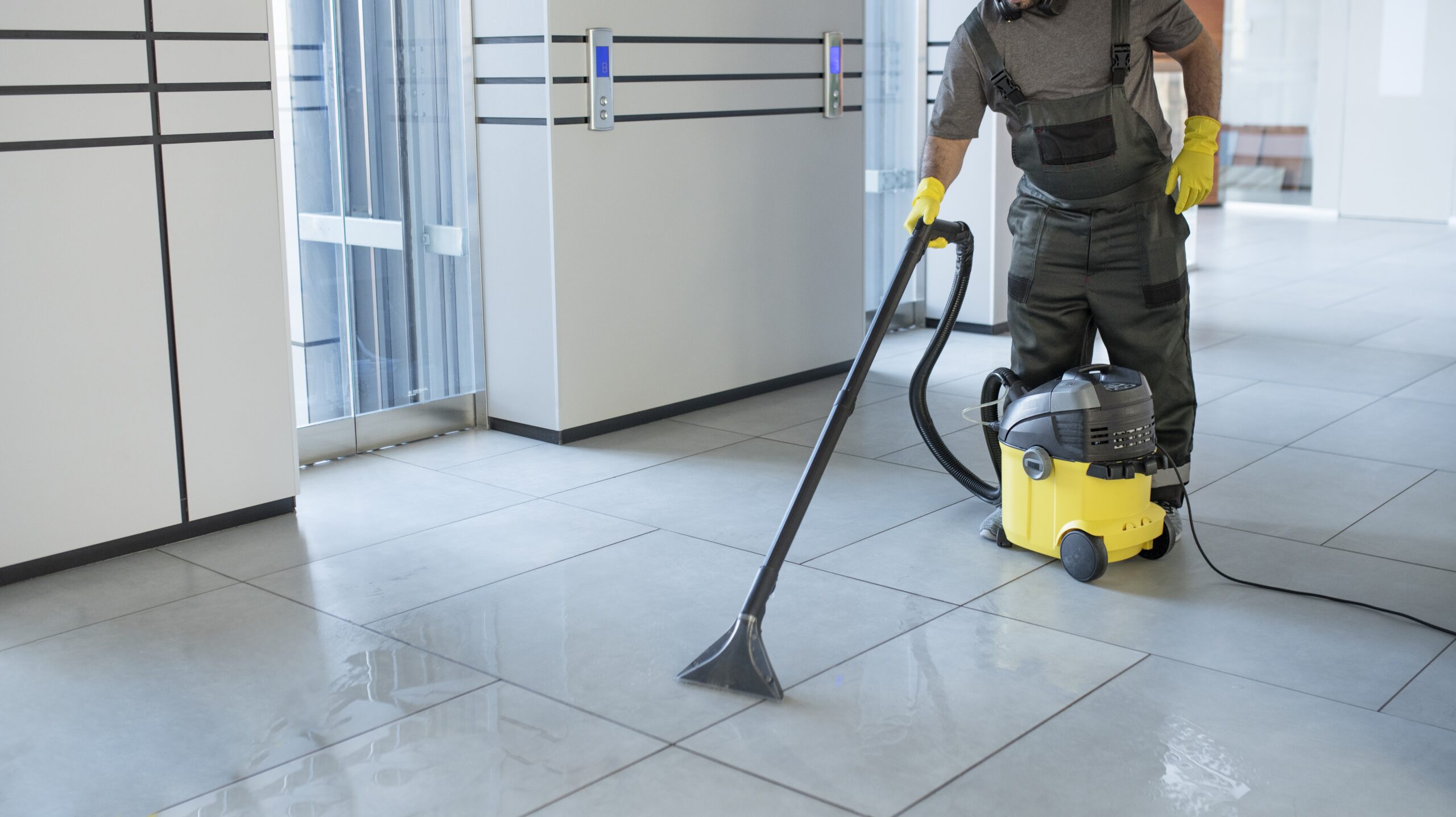 nettoyage professionnel de parking souterrains à Le Havre Seine-Maritime 76 Normandie. Technicien Proclean nettoyant devant l'ascenseur d'un parking commercial